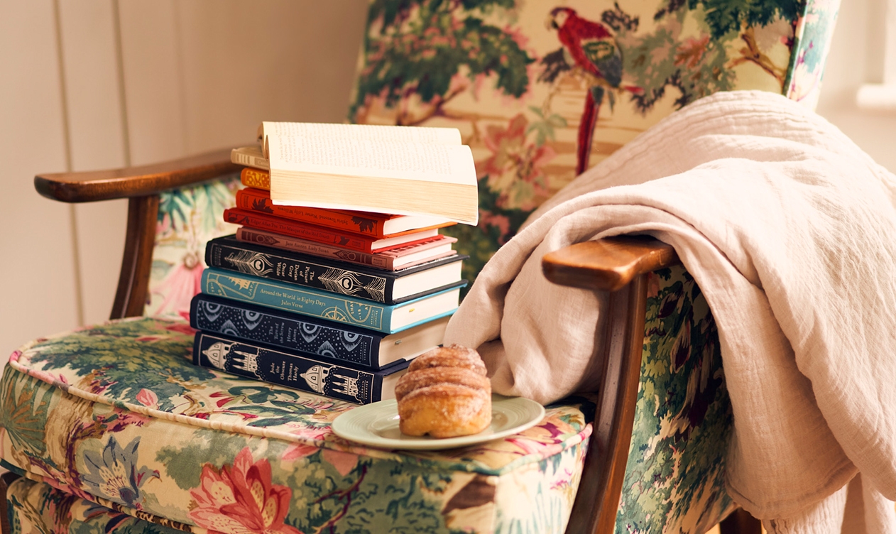 Image of Chair with a pile of books, cake and blanket